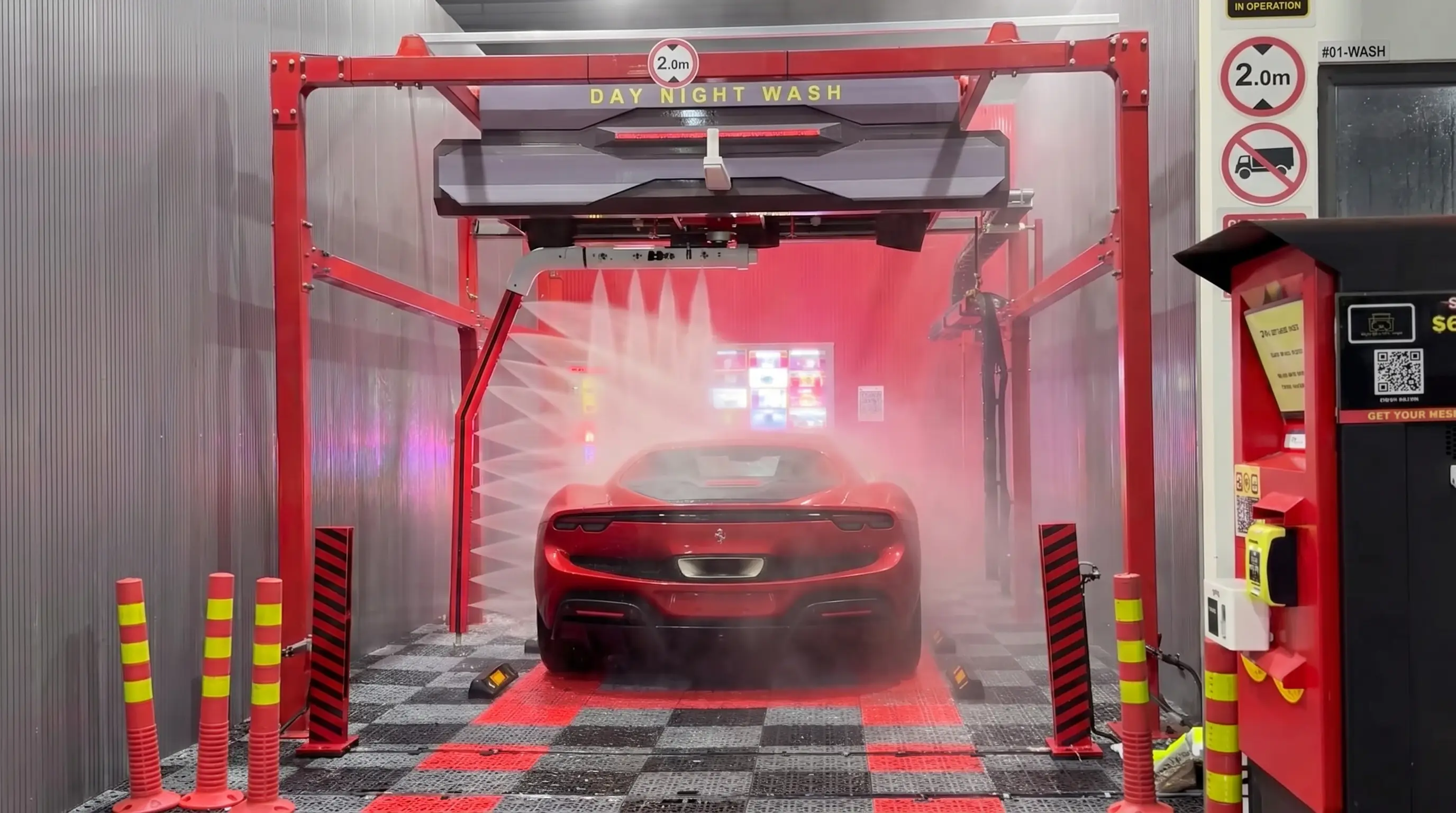 Car being cleaned by touchless high-pressure jets in a dark automated wash bay